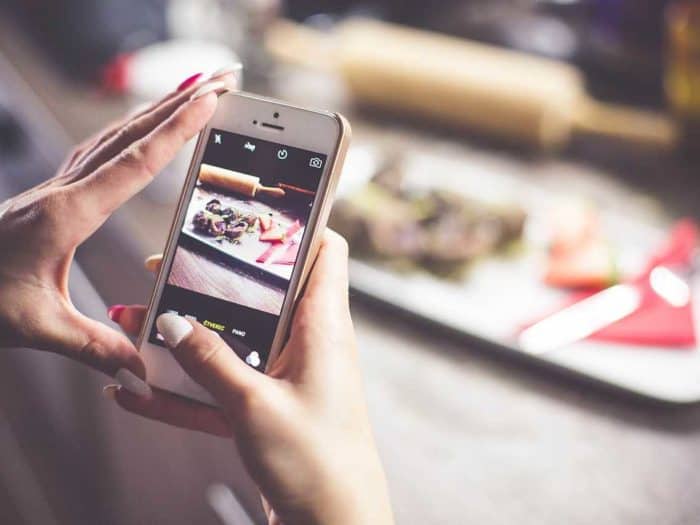 Girl taking a photo of her food with iphone