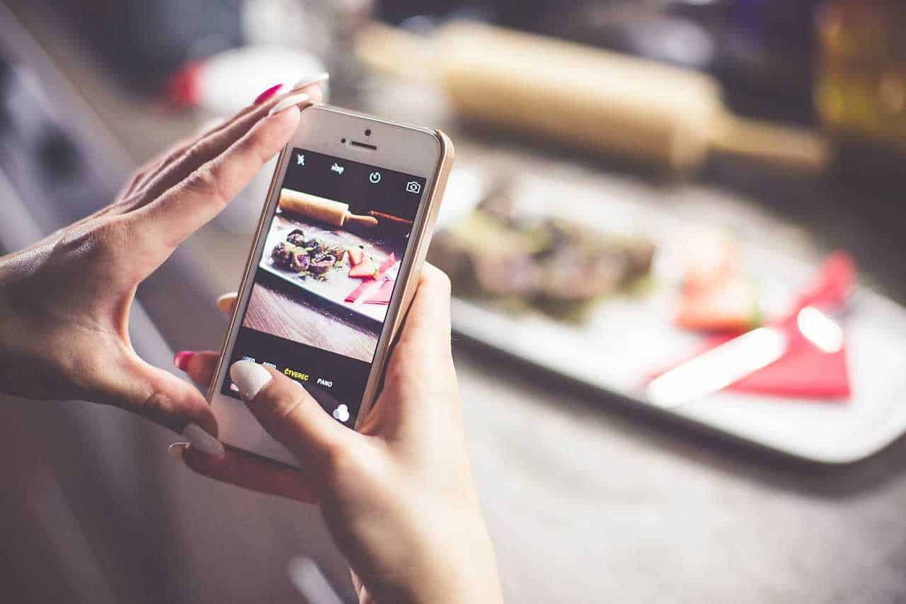 Girl taking a photo of her food with iphone